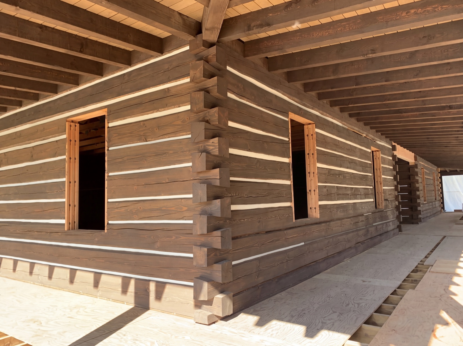 Log home chinking in Pemberton Meadows BC - white chinking between hand-hewn dovetail log courses