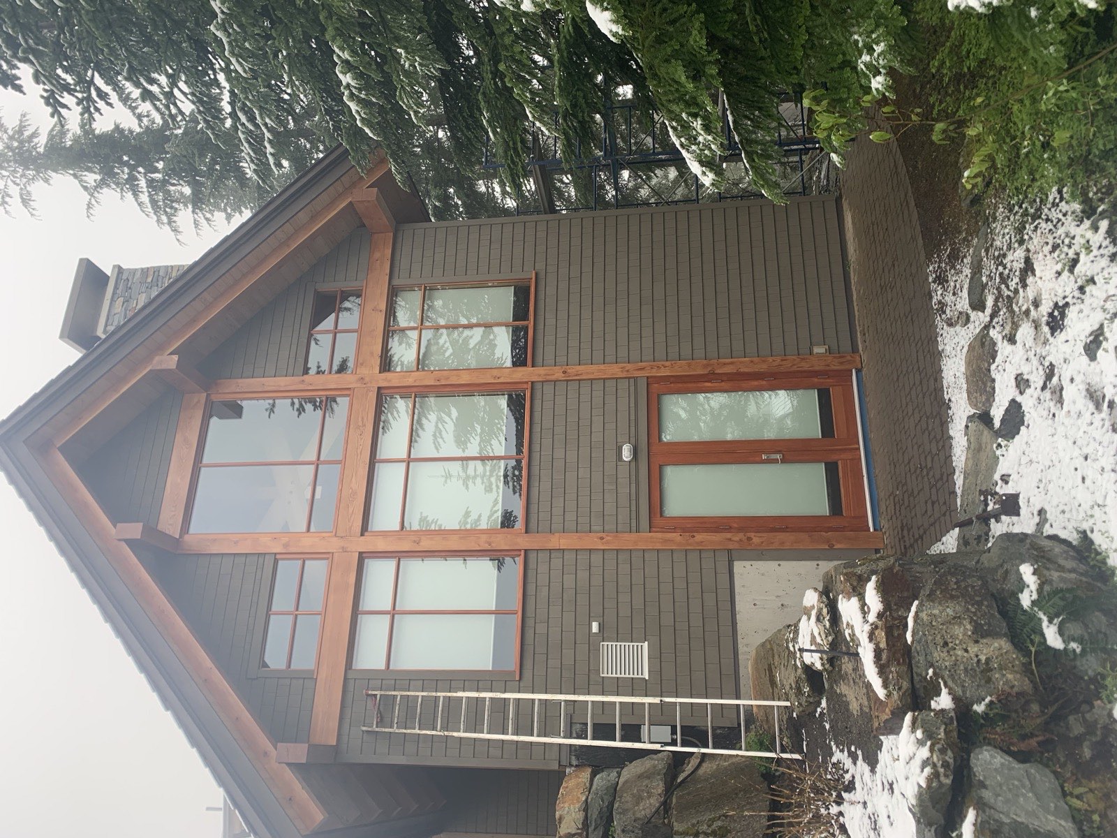 Timber home restoration Whistler BC - completed exterior after staining, first snow